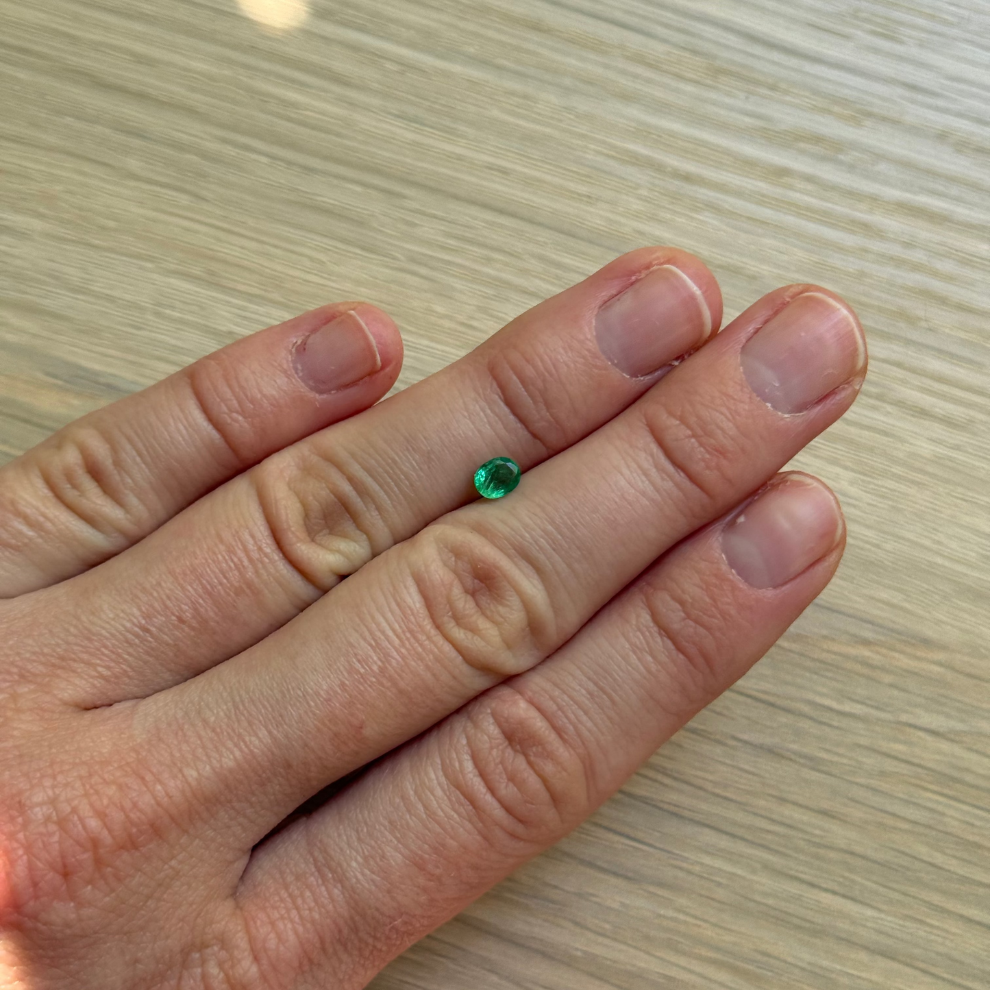 Hand with a green emerald gemstone