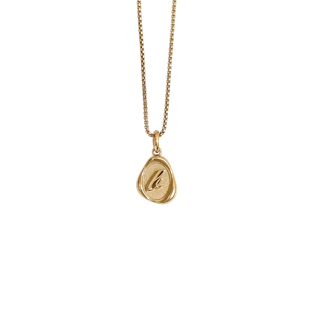 Solid 14k gold charm necklace with custom initial on white background