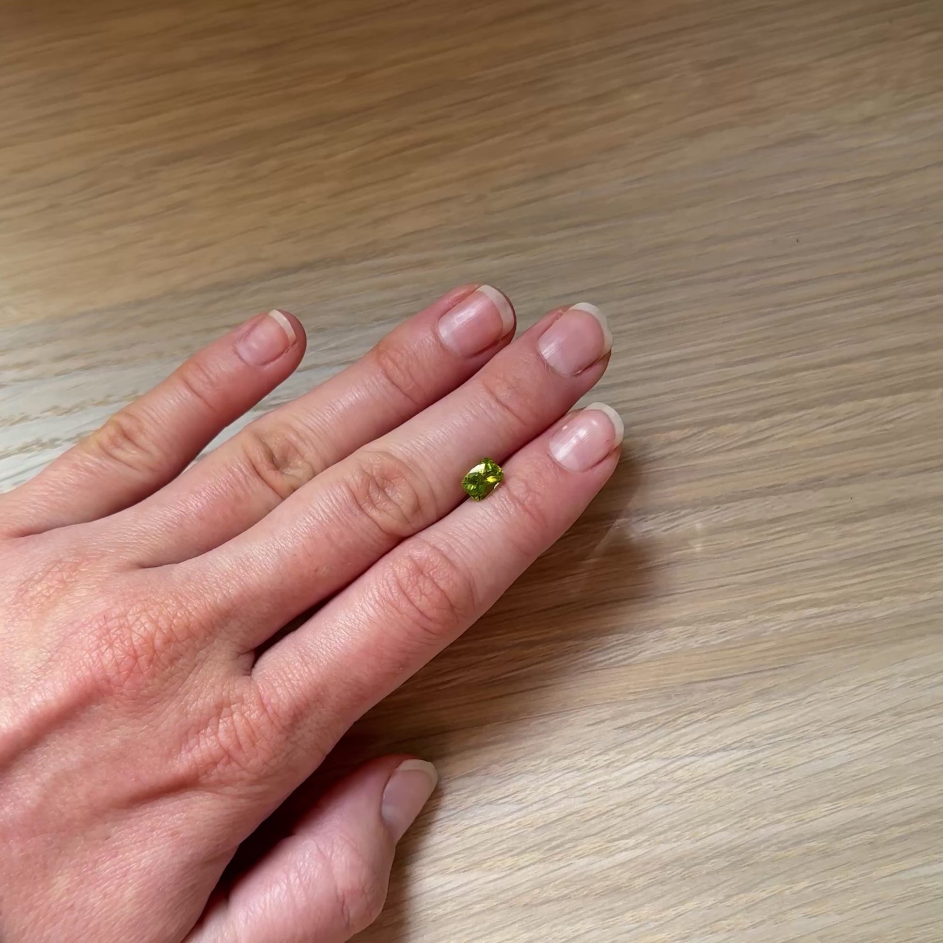 Hand with a green peridot gemstone