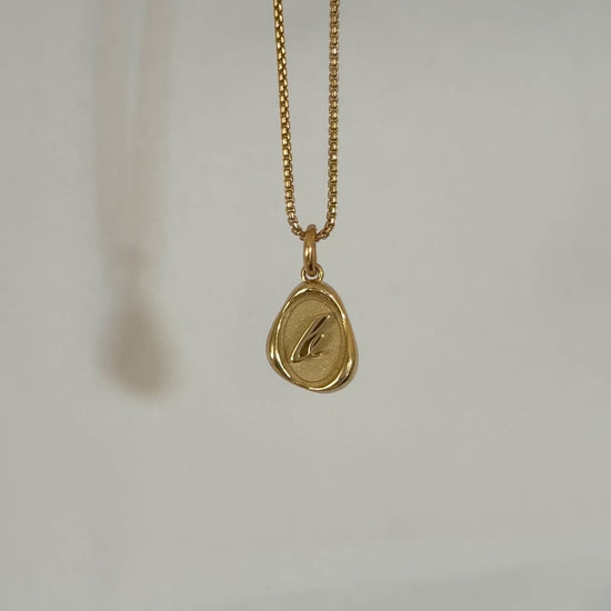 Solid 14k gold charm necklace with custom initial dangling on a chain