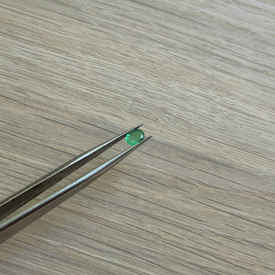 Tweezers with a green emerald gemstone