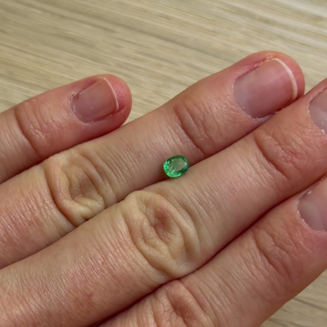 Hand with a green emerald gemstone